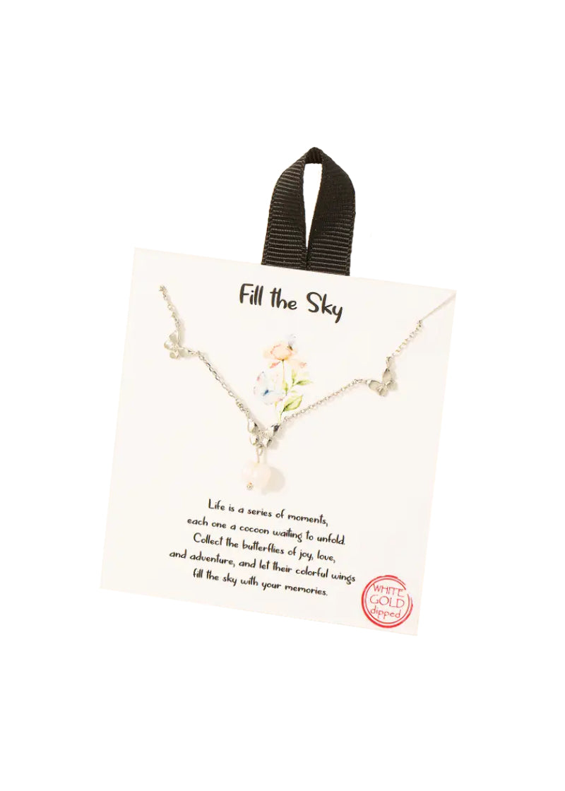 Silver chain necklace with three silver butterfly charms and a pearl dangling from the center butterfly.