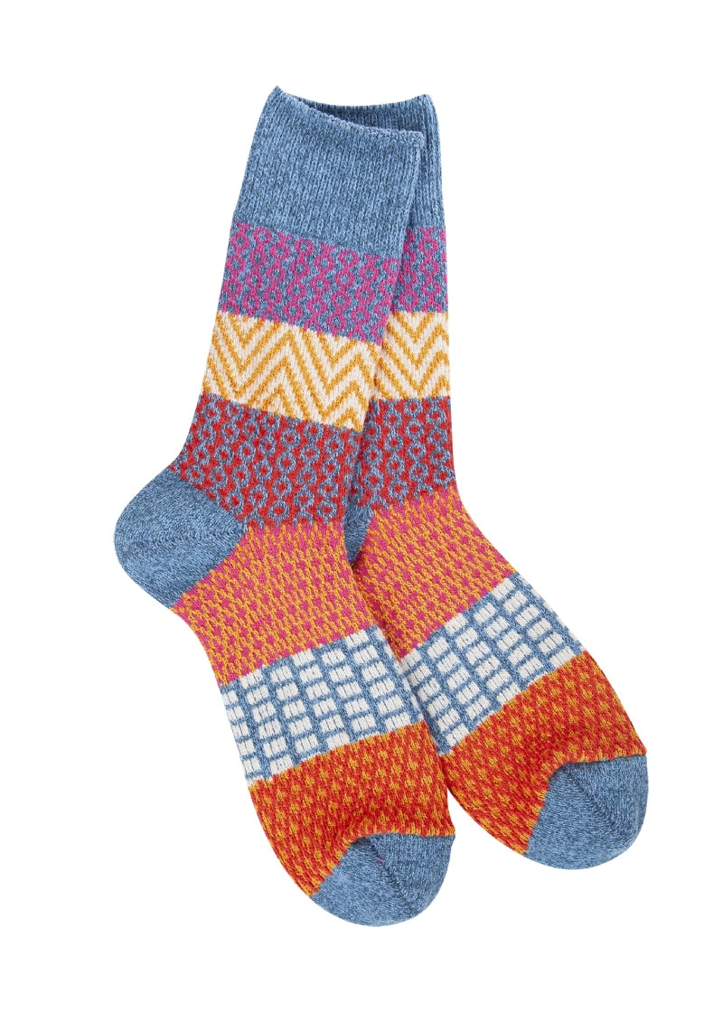 denim blue knit socks with red, pink, orange, and yellow geometric patterns