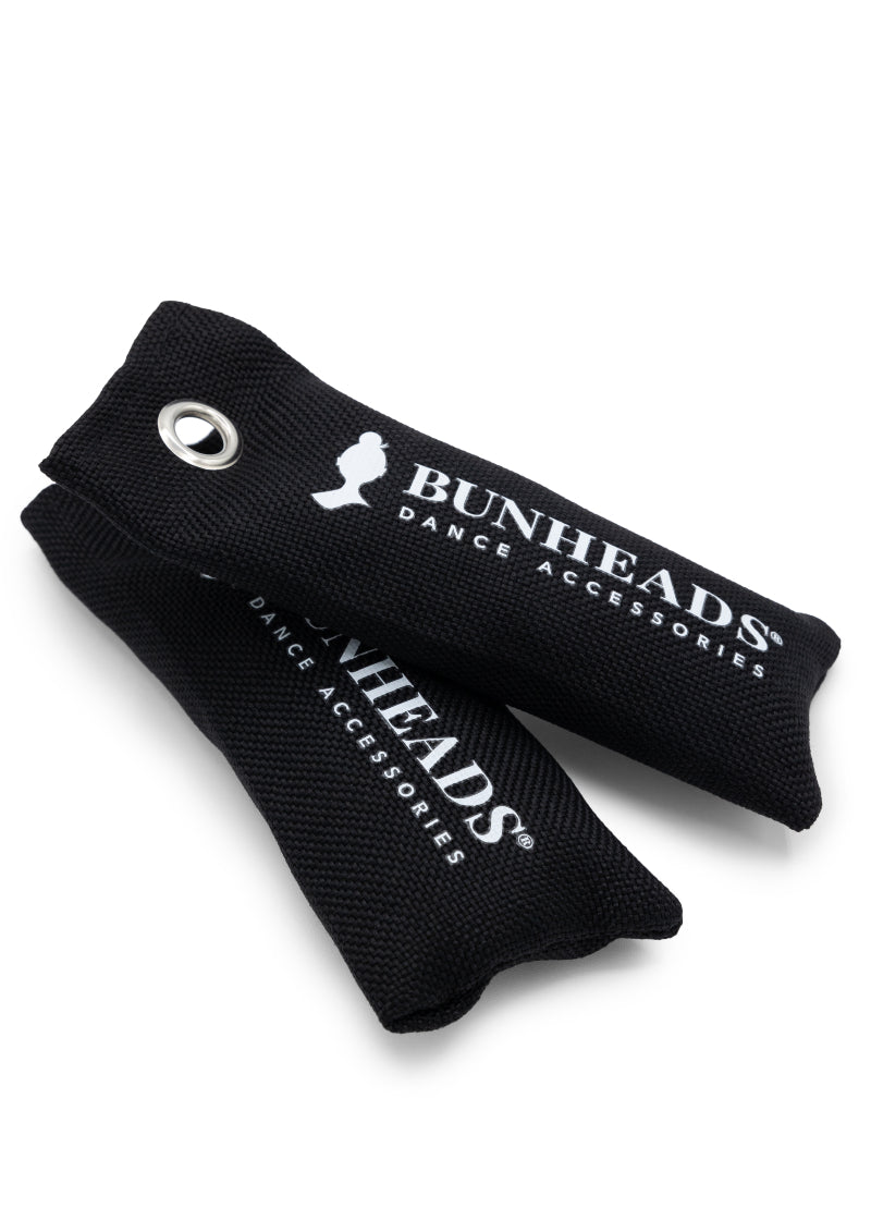 Two black deodorizing pouches with keyholes and Bunheads Dance Accessories printed in white.