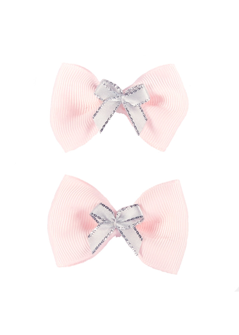 Two light pink bows made of ribbed ribbon. In the center of each bow is a smaller, white bow with a silver border.