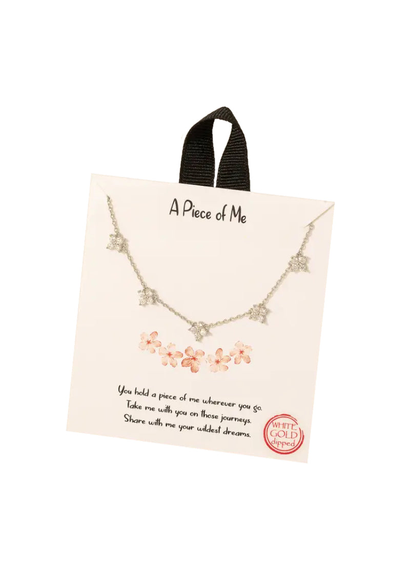 Silver chain necklace with five cubic zirconia flower charms.