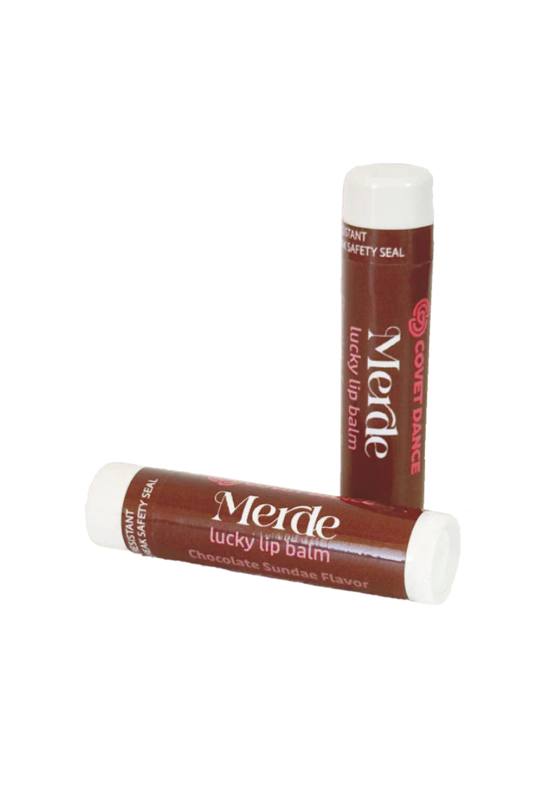 Two brown tubes of "Merde" lucky lip balm.