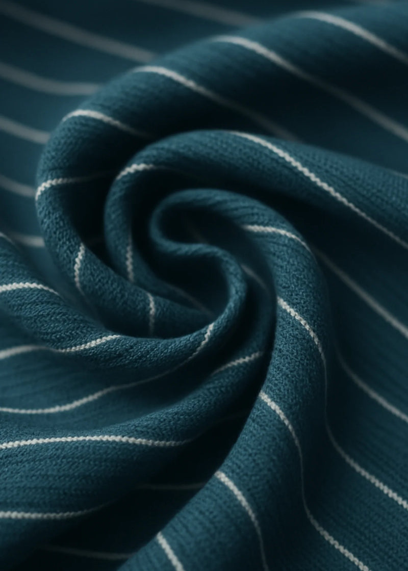 Close-up of dark teal fabric with thin white stripes.
