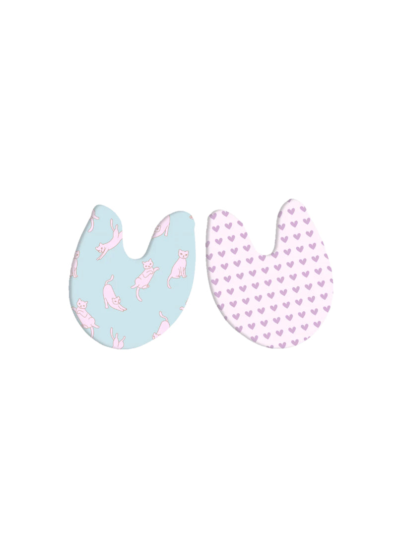 Toe pads with pink cats on blue background on one side and purple hearts on pick background on the other side.