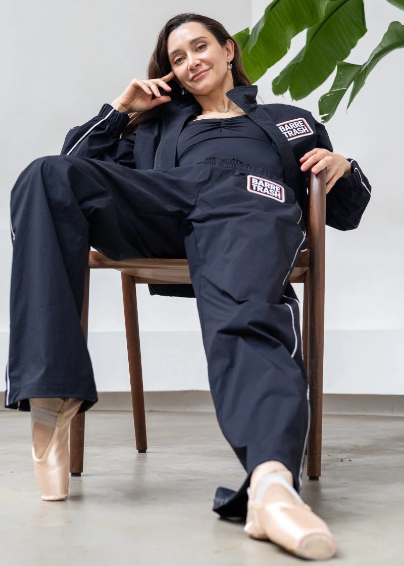 Barre Trash Tracksuit Pants in black with elastic waistband, drawstring leg opening, and pinstripe details