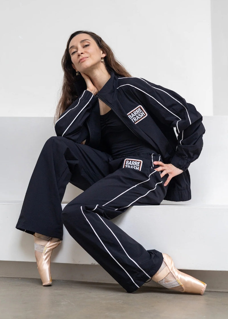 Barre Trash Tracksuit Pants in black with elastic waistband, drawstring leg opening, and pinstripe details