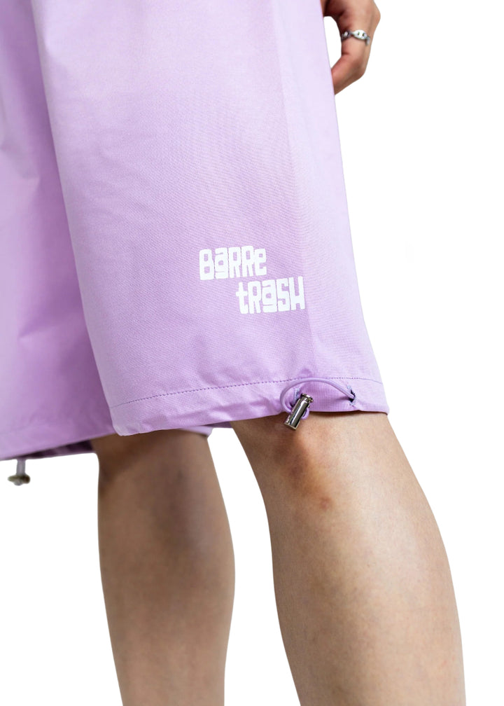 Barre Trash Women's Sauna Shorts in Lilac purple with adjustable drawstring leg openings and the Barre Trash logo in white printed on the lower left leg, modeled by a ballet dancer