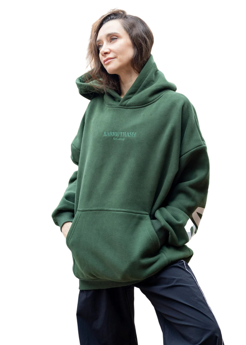 Barre Trash OH Women's Oversized Hoodie in Emerald Green with tone-on-tone embroidery of "Barre Trash Est. 2023" on the front, modeled by a ballet dancer