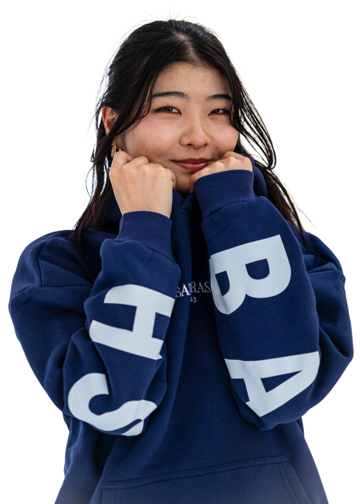 Barre Trash OH Women's Oversized Hoodie in Mariner Navy Blue with the Barre Trash logo in white lettering across the sleeves & back, modeled by a ballet dancer
