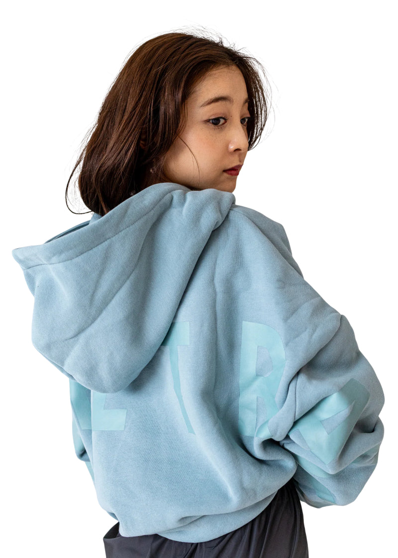 Barre Trash OH Oversized Hoodie in Powder Blue with tone-on-tone lettering, modeled by a ballet dancer