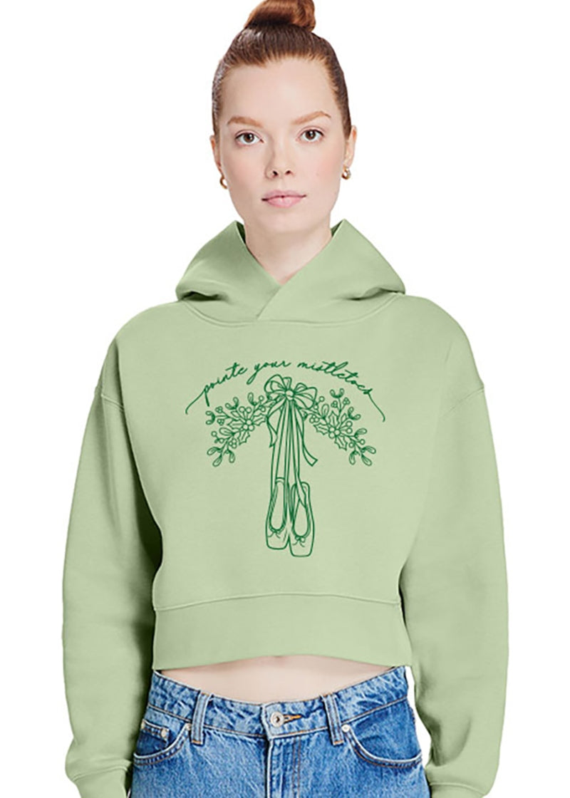 Covet cropped hoodie in Matcha Green with dark green screen printed pointe shoes and mistletoe with the words "pointe your mistletoes"