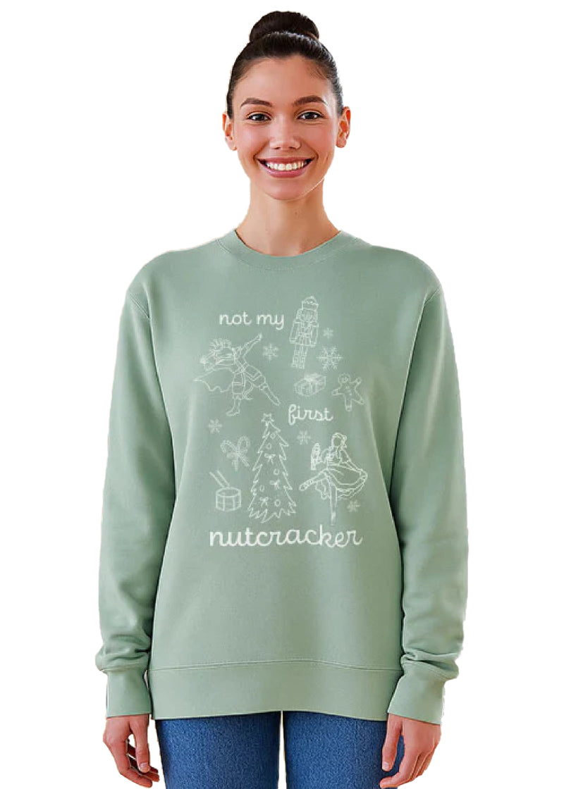 Covet Dance NMFN-SS Not My First Nutcracker Women's Crewneck Sweatshirt in Mint Green with Nutcracker Ballet-themed doodles printed in white, shown on a model wearing blue jeans