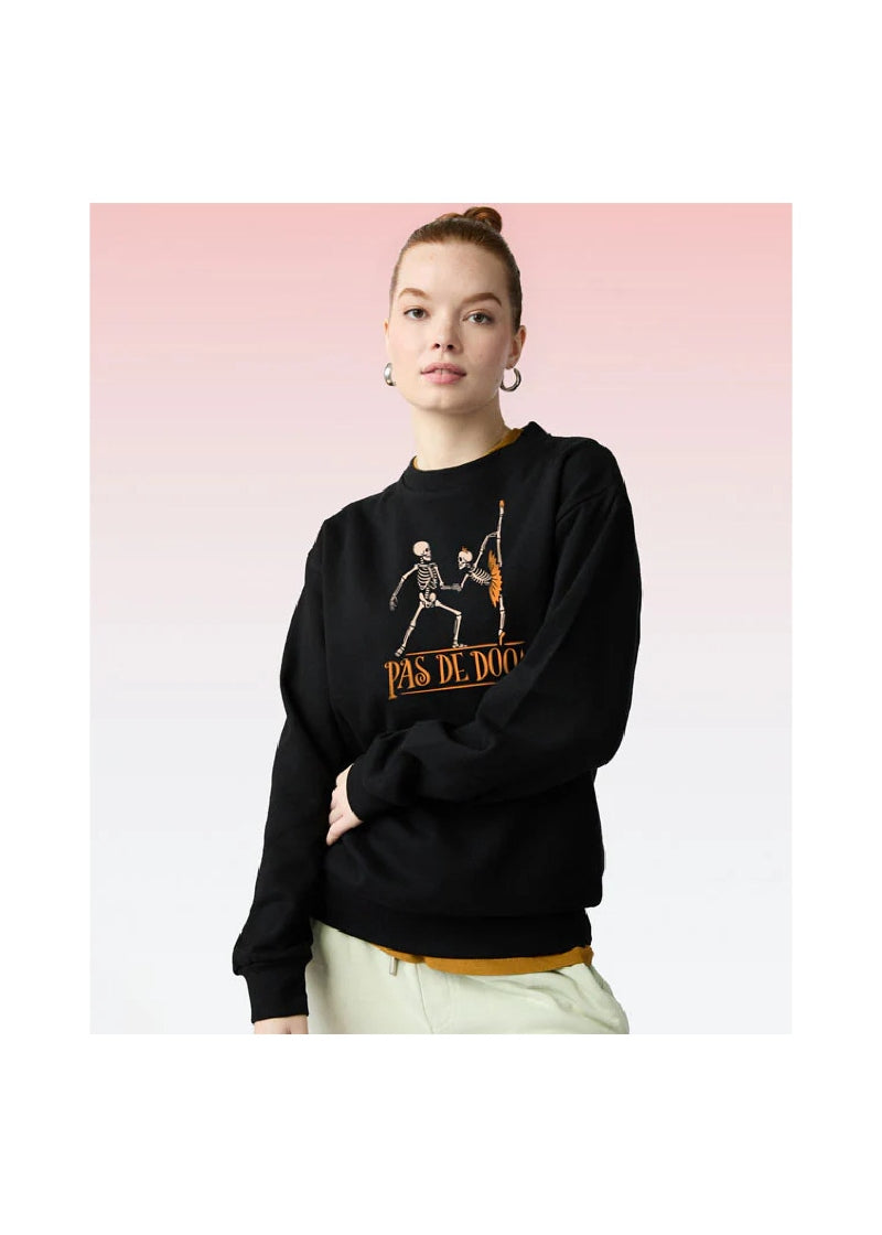 woman wearing a black crew neck sweatshirt with dancing skeletons and the words "pas de doom"