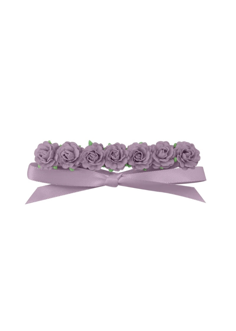 Seve pinkish purple flowers in a row, attached to a matching ribbon.