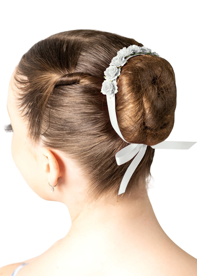 White flowers and ribbon tied around a ballerina's bun.