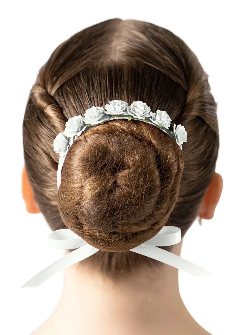 White flowers and ribbon tied around a ballerina's bun.