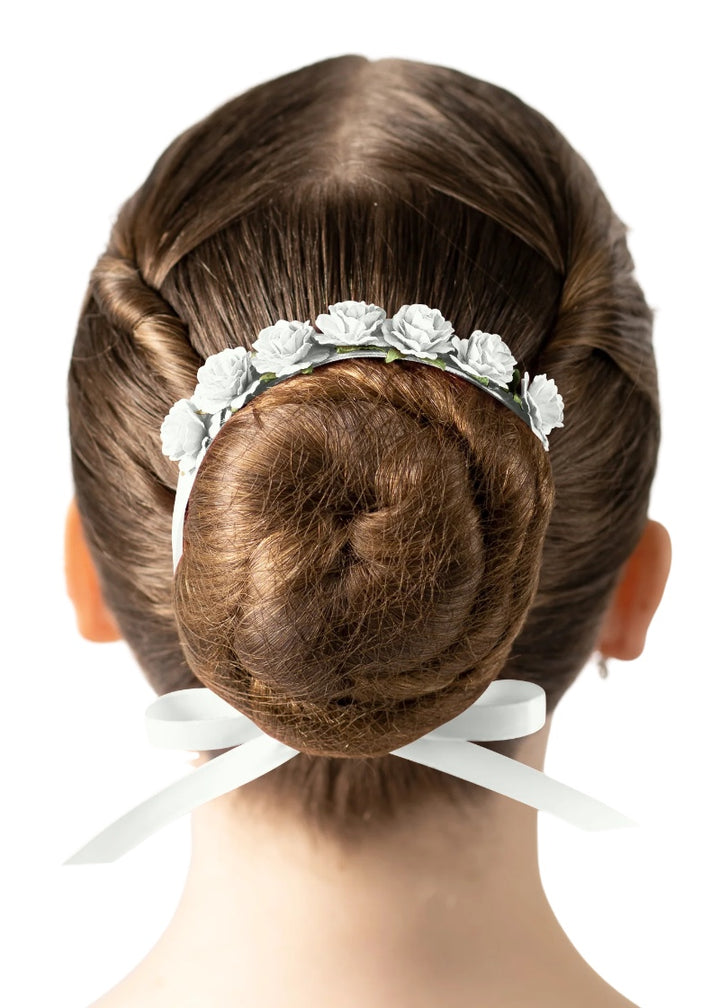 White flowers and ribbon tied around a ballerina's bun.