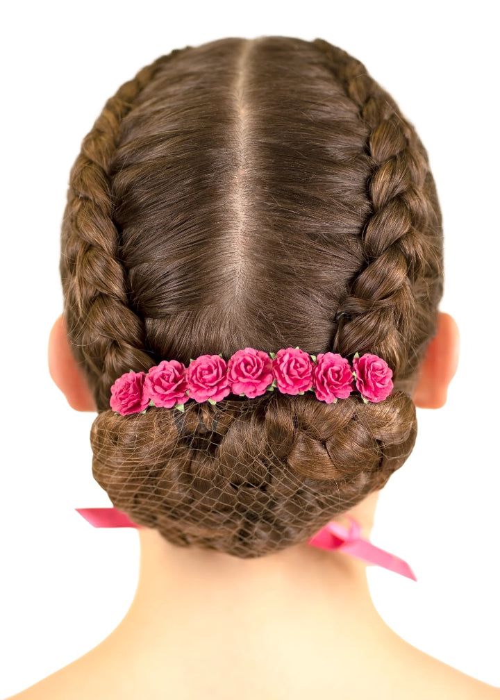Pink flowers and ribbon tied around a ballerina's bun.