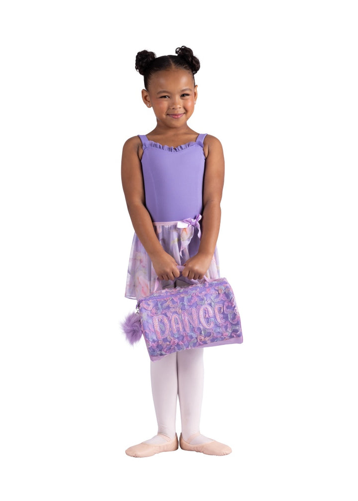 Danznmotion small duffel bag in light purple with pink and blue petal texture, shiny "DANCE" appliqué, purple poof keychain, top zipper, and carrying handle.