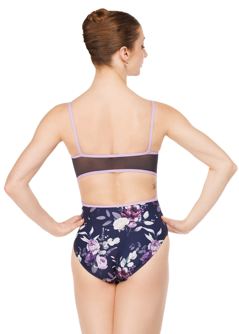 Eleve Dancewear Moonlit Garden Women's Helena Camisole Leotard with all over white, purple, and navy blue floral print and mesh low-cut open back, shown on a ballet dancer