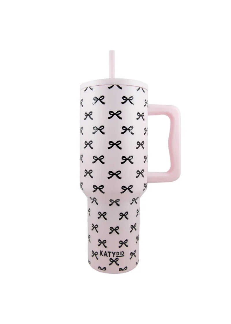light pink tumbler with straw, handle, and black bow pattern