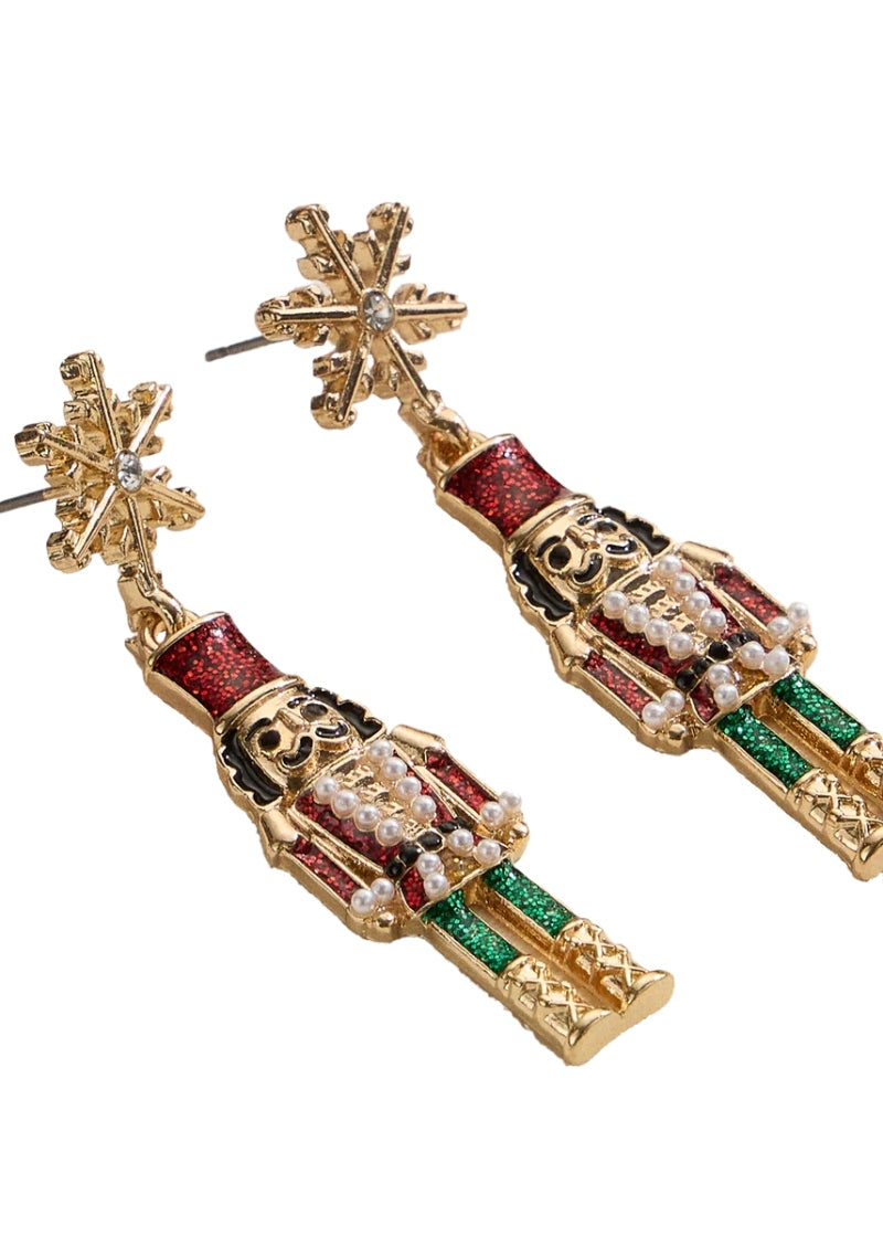gold plated holiday nutcracker shaped earrings with red and green enamel hanging from a snowflake-shaped post