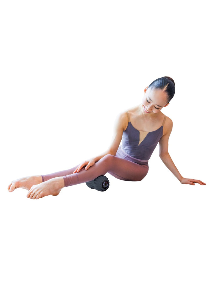 Dancer using peanut shaped muscle roller to massage her calf.