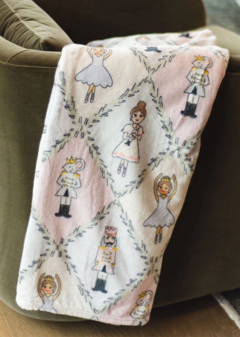 Fleece blanket with nutcracker character art in pastel argyle pattern.