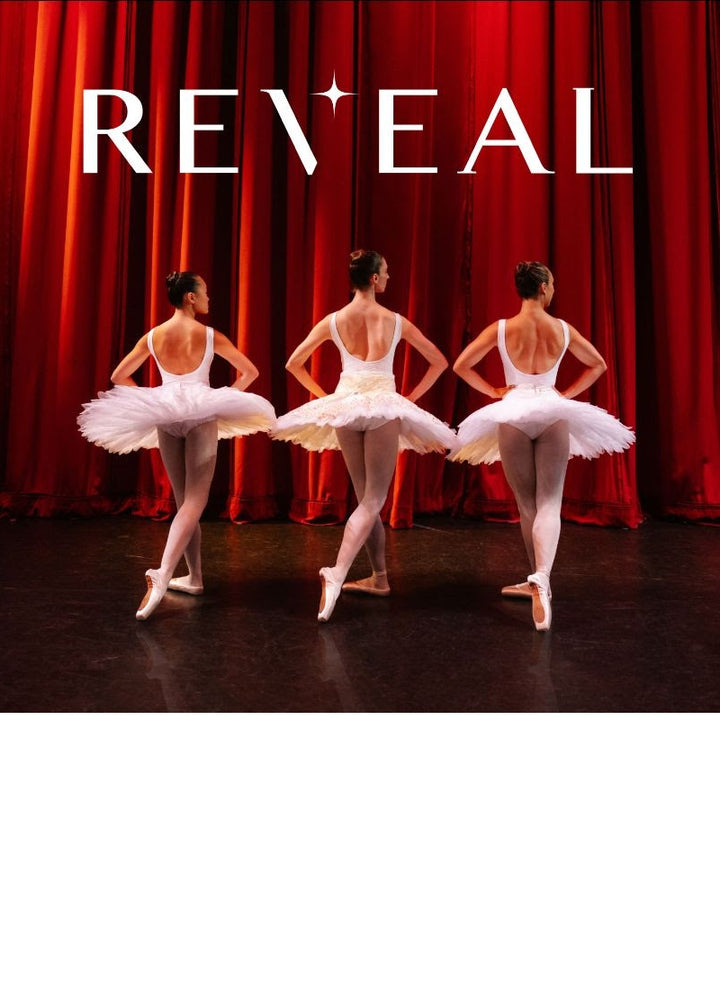 Trio of ballerinas dressed in white tutus standing onstage and ready to perform in their Reveal Pointe Shoes