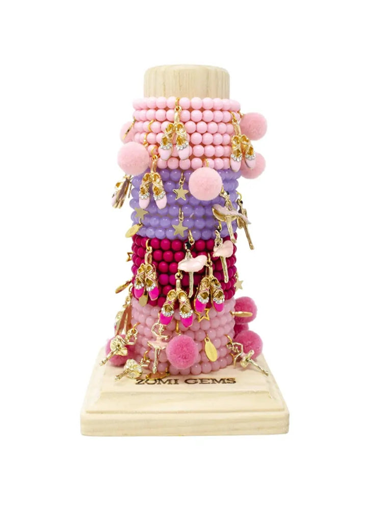 tower of beaded bracelets of various styles in pink and purple